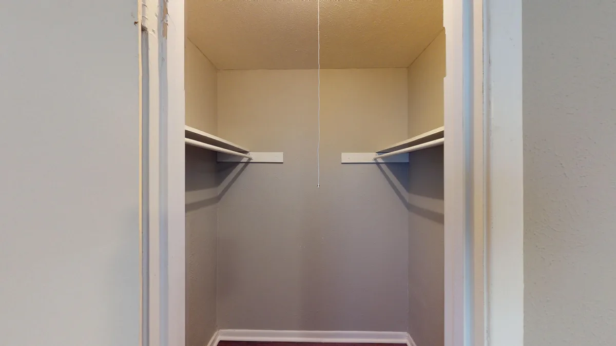 Walk-in closet with built-in shelving and a hanging rod