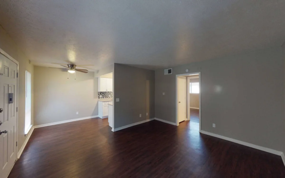Spacious open living and dining area with ceiling fan and view into the kitchen