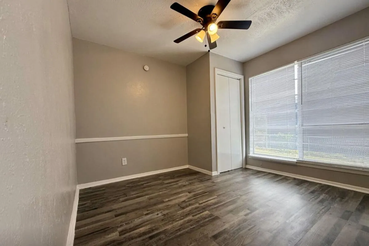 Bedroom with wood-style flooring, ceiling fan, closet, and large window at La Madera in Dallas