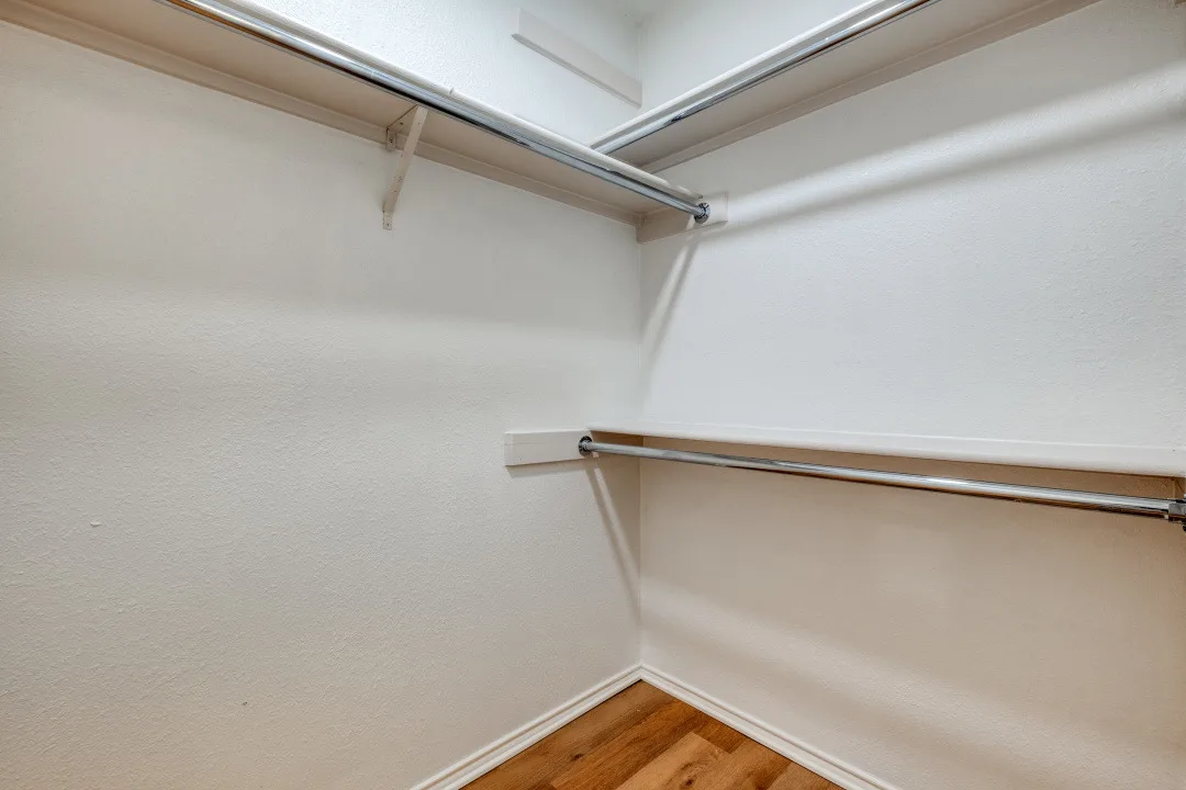 Walk-in closet with wraparound wire shelving and hanging rods