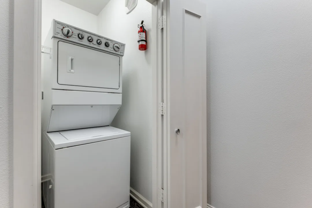 In-unit stacked washer and dryer in a closet with wire shelving
