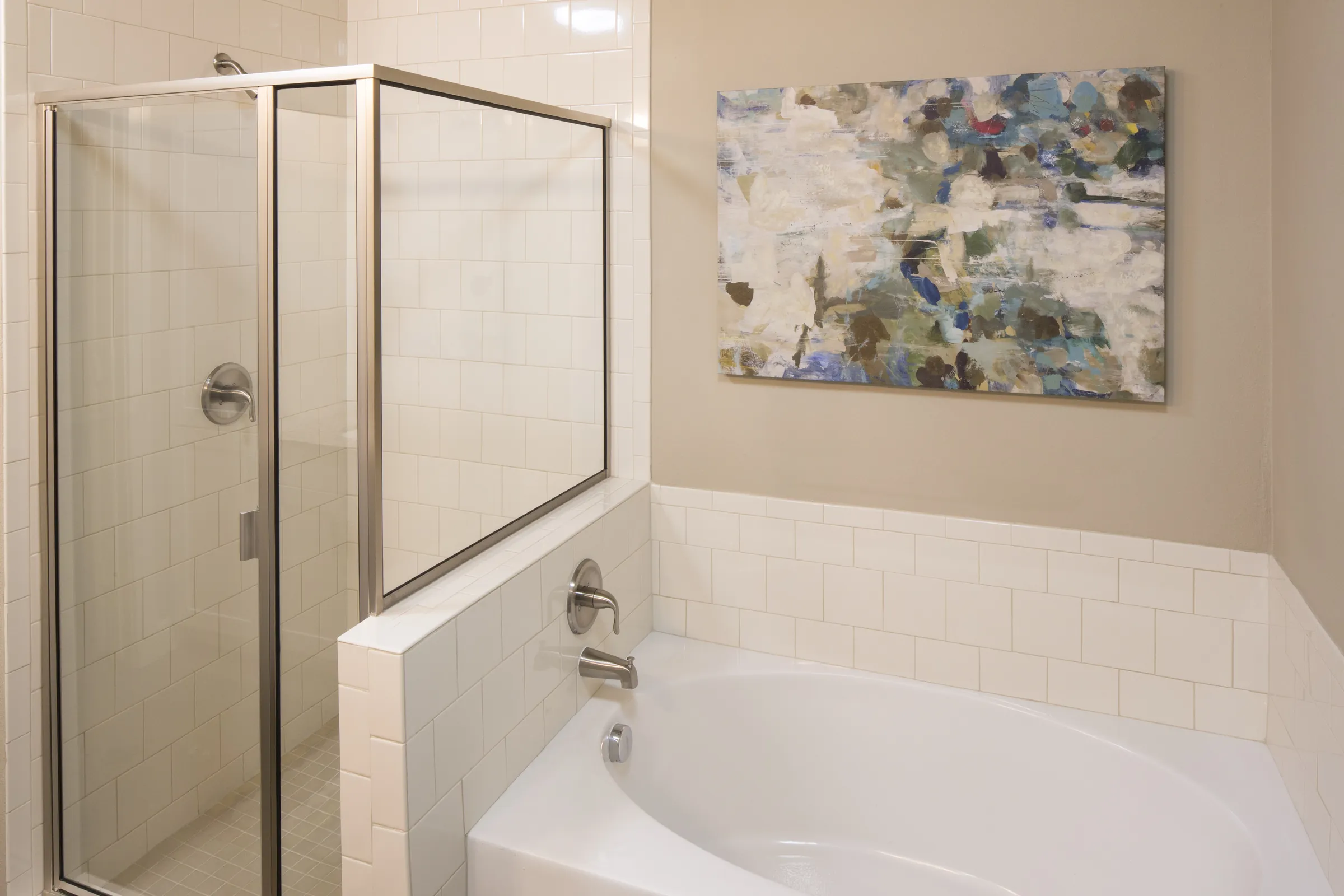 A bathroom with a soaking tub and a separate glass-enclosed tile shower