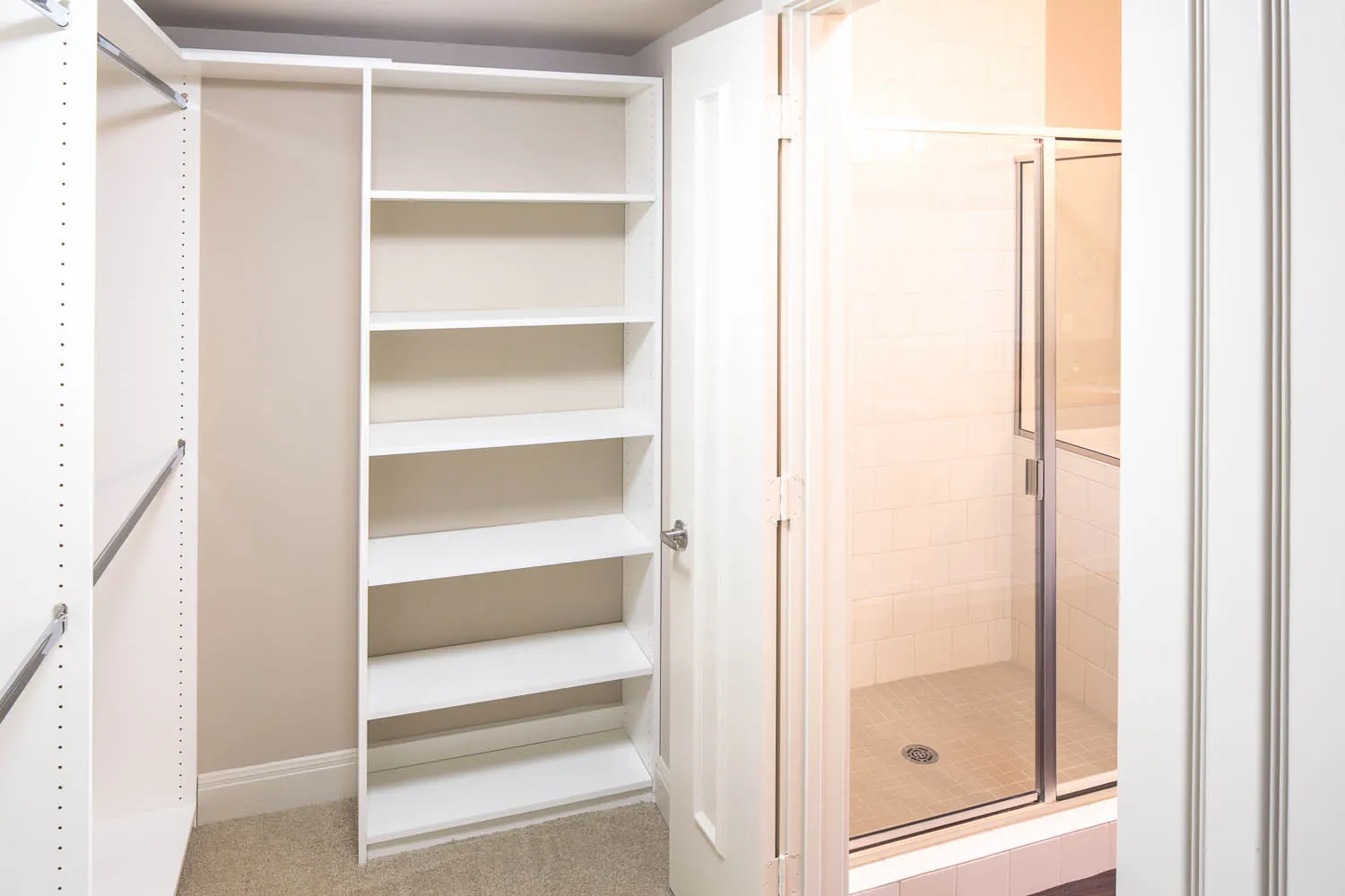 A walk-in closet with built-in shelving and hanging rods