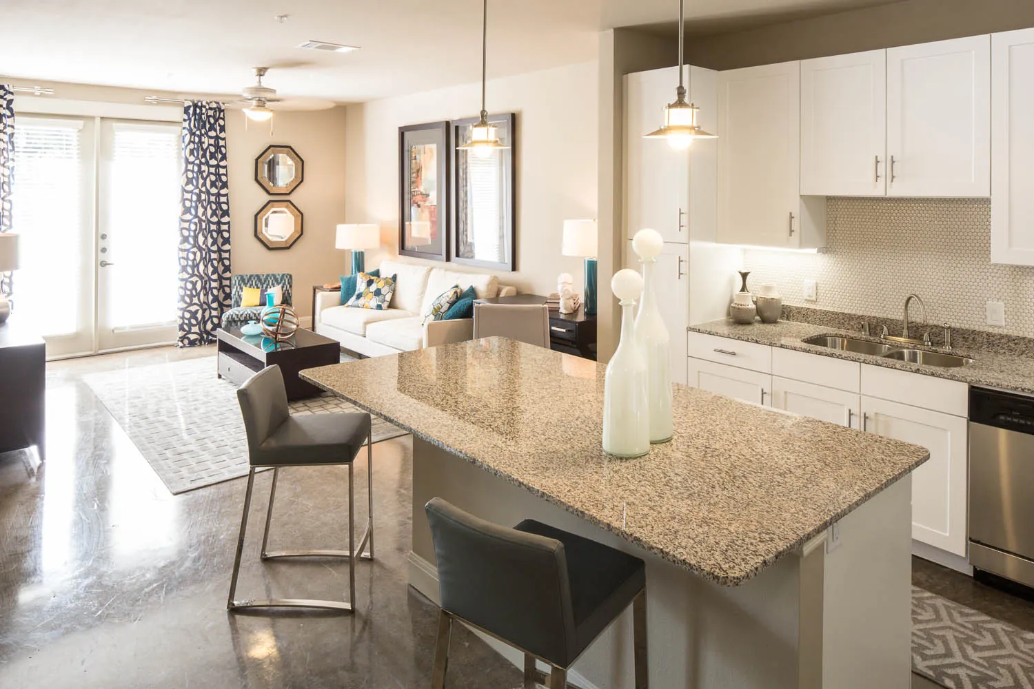 A granite island with two bar stools, open to the living room