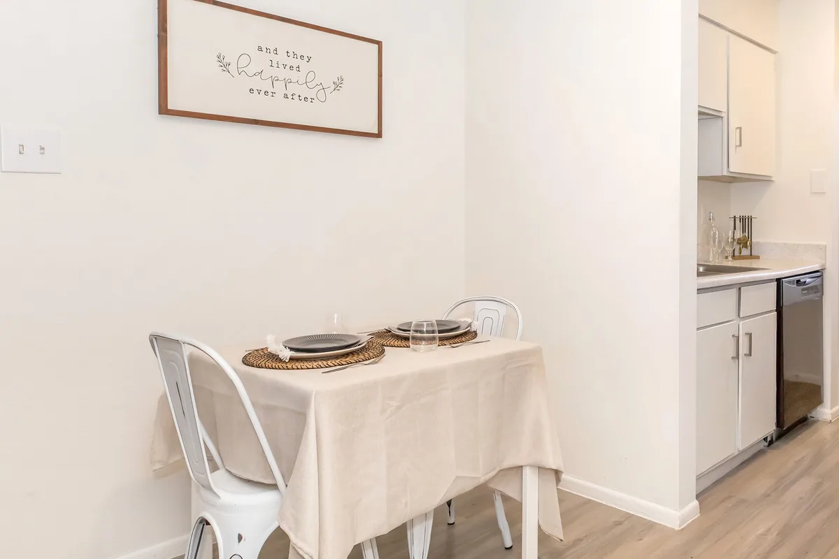 Cozy dining nook seating two beside the kitchen with wood-look flooring