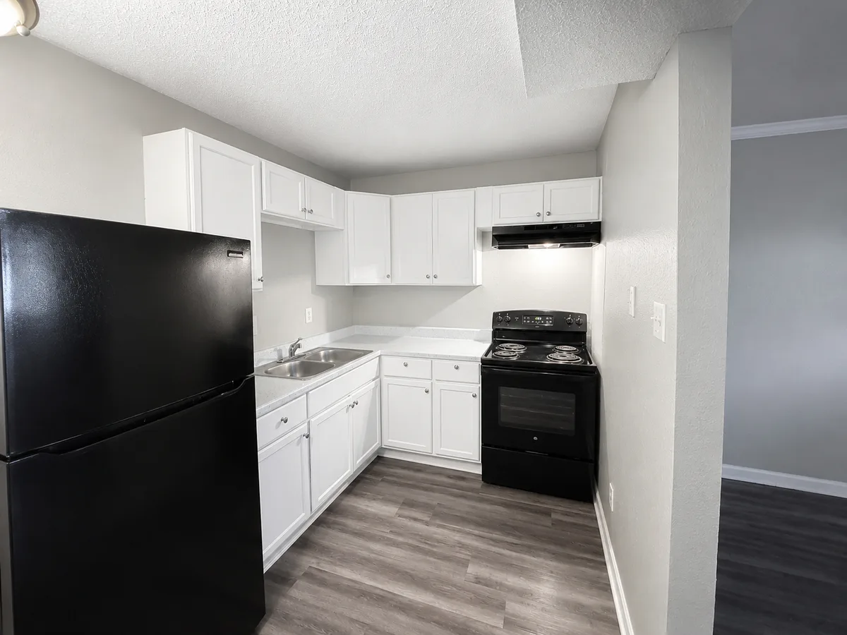 Kitchen with white cabinetry, black refrigerator, electric range, and wood-look plank flooring
