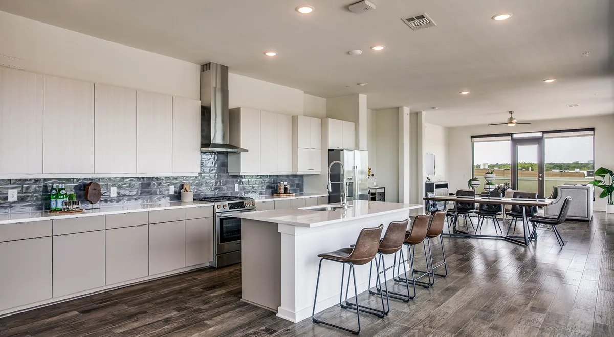 Clubroom bar and demonstration kitchen with island seating overlooking the pool