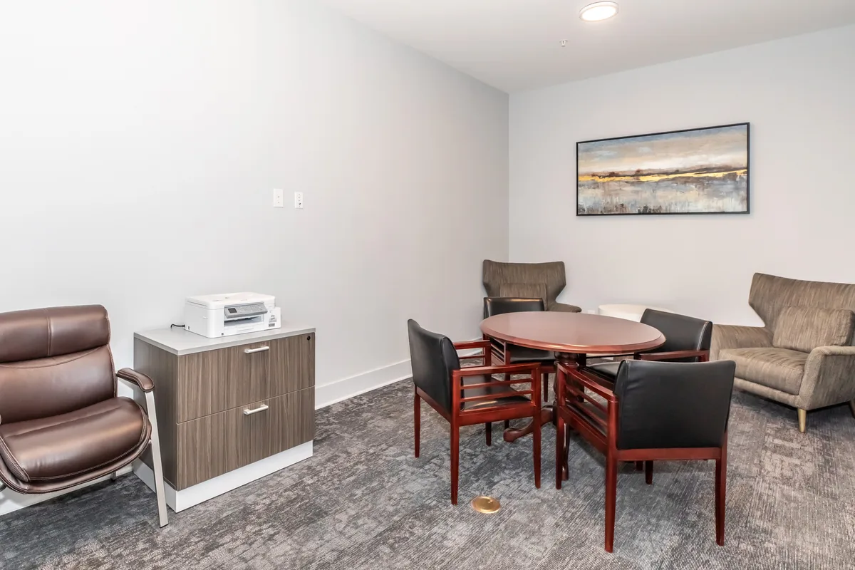 Private workspace and conference room with round table, printer and lounge seating