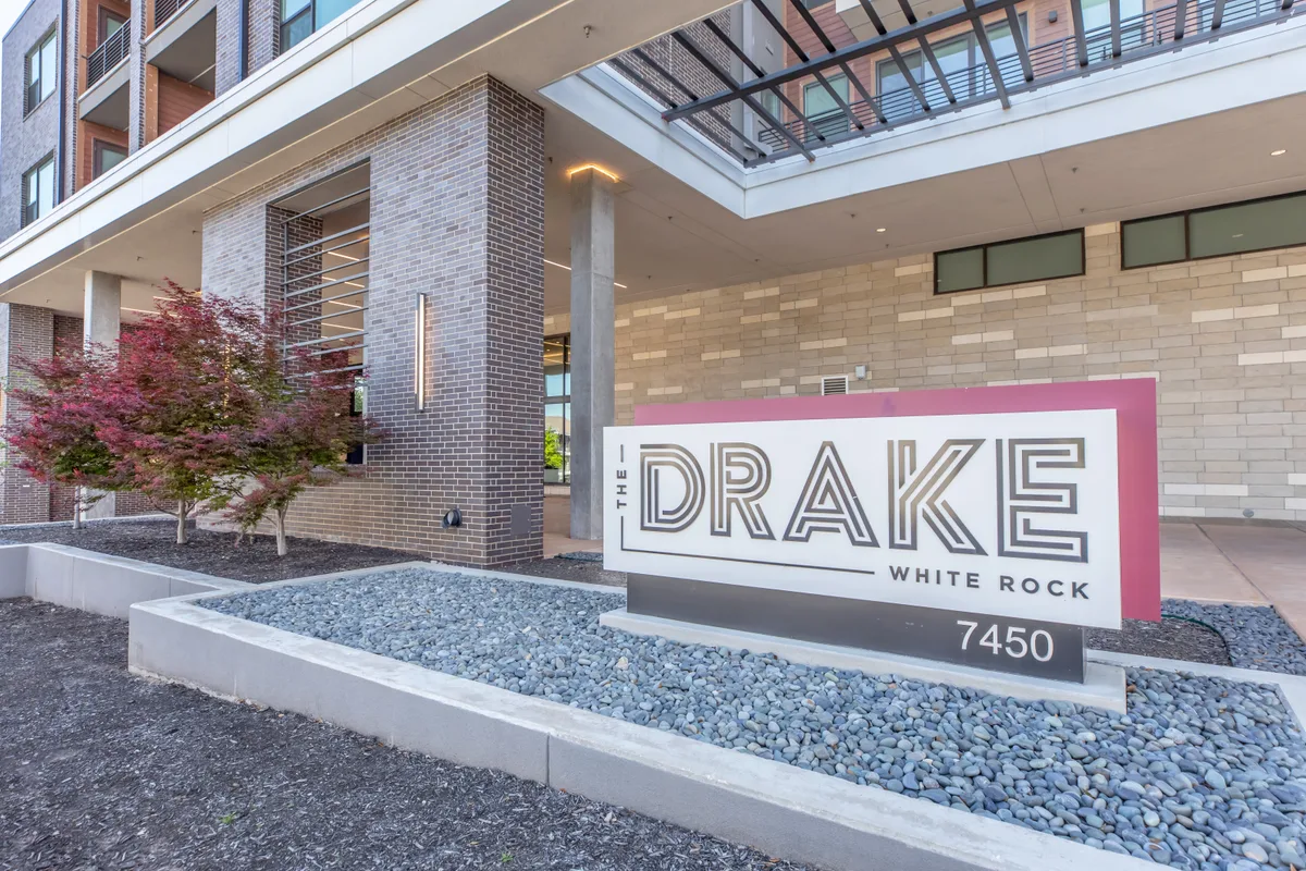The Drake White Rock monument entrance sign framed by red Japanese maples