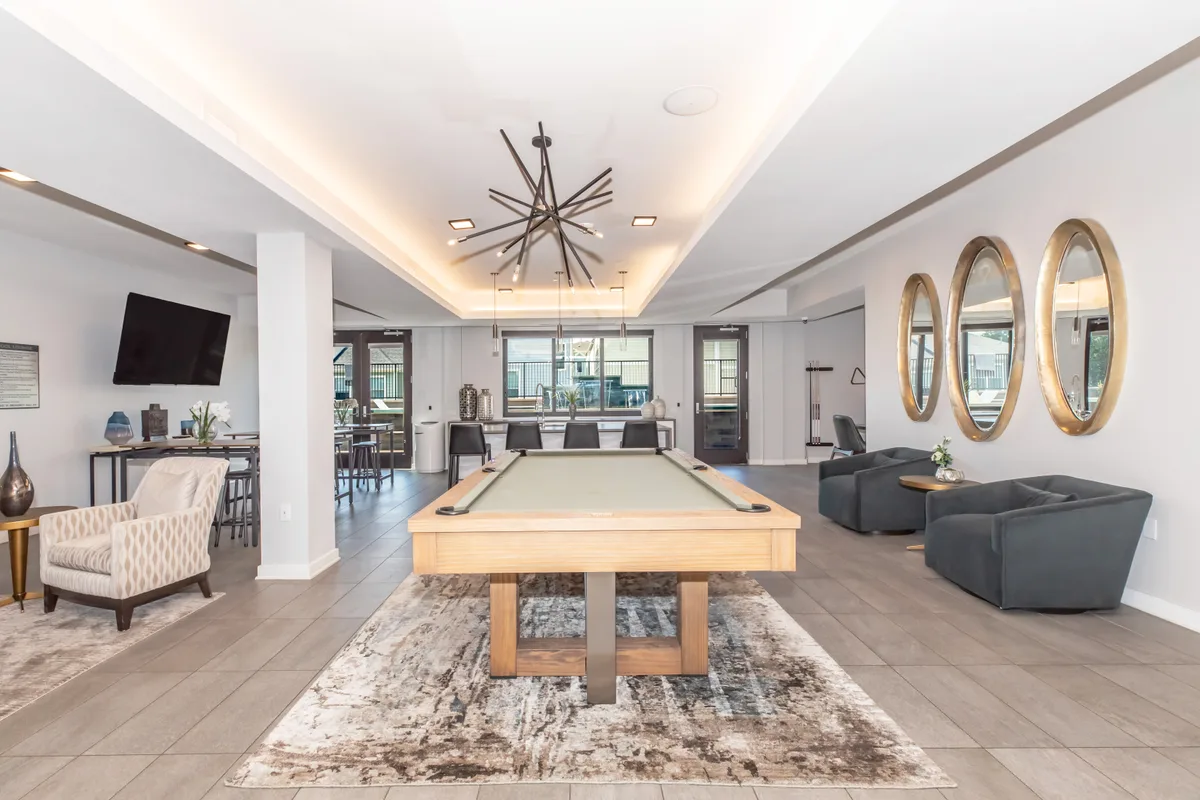 Game lounge with billiards table, gold oval mirrors and velvet swivel chairs