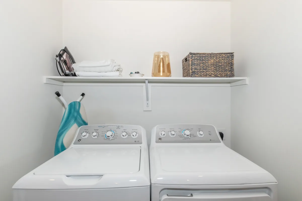 In-unit full-size washer and dryer with shelf and ironing station
