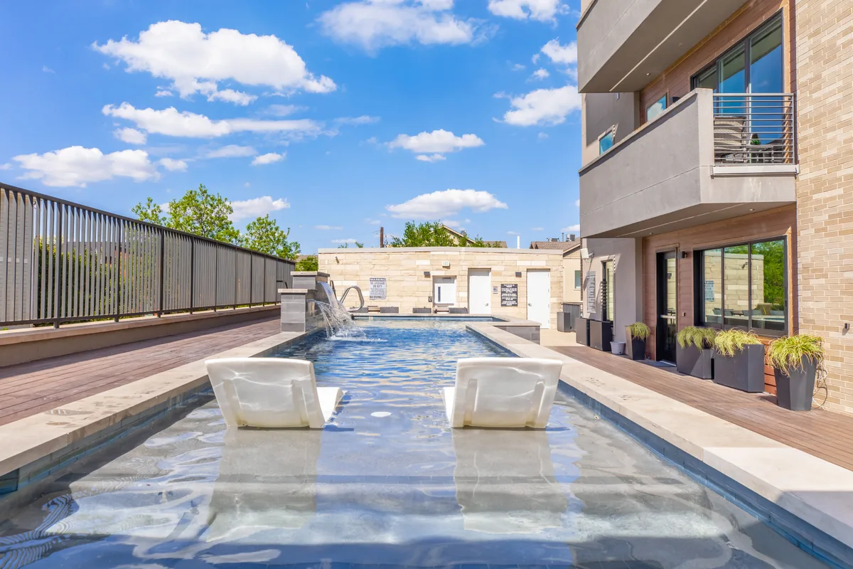 Swimming pool with in-water tanning-ledge loungers and a wood-look sundeck
