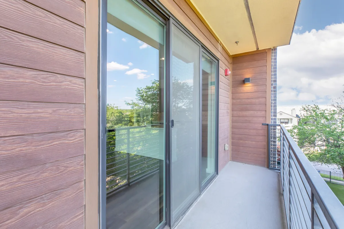 Private balcony with wood-look siding and leafy neighborhood views