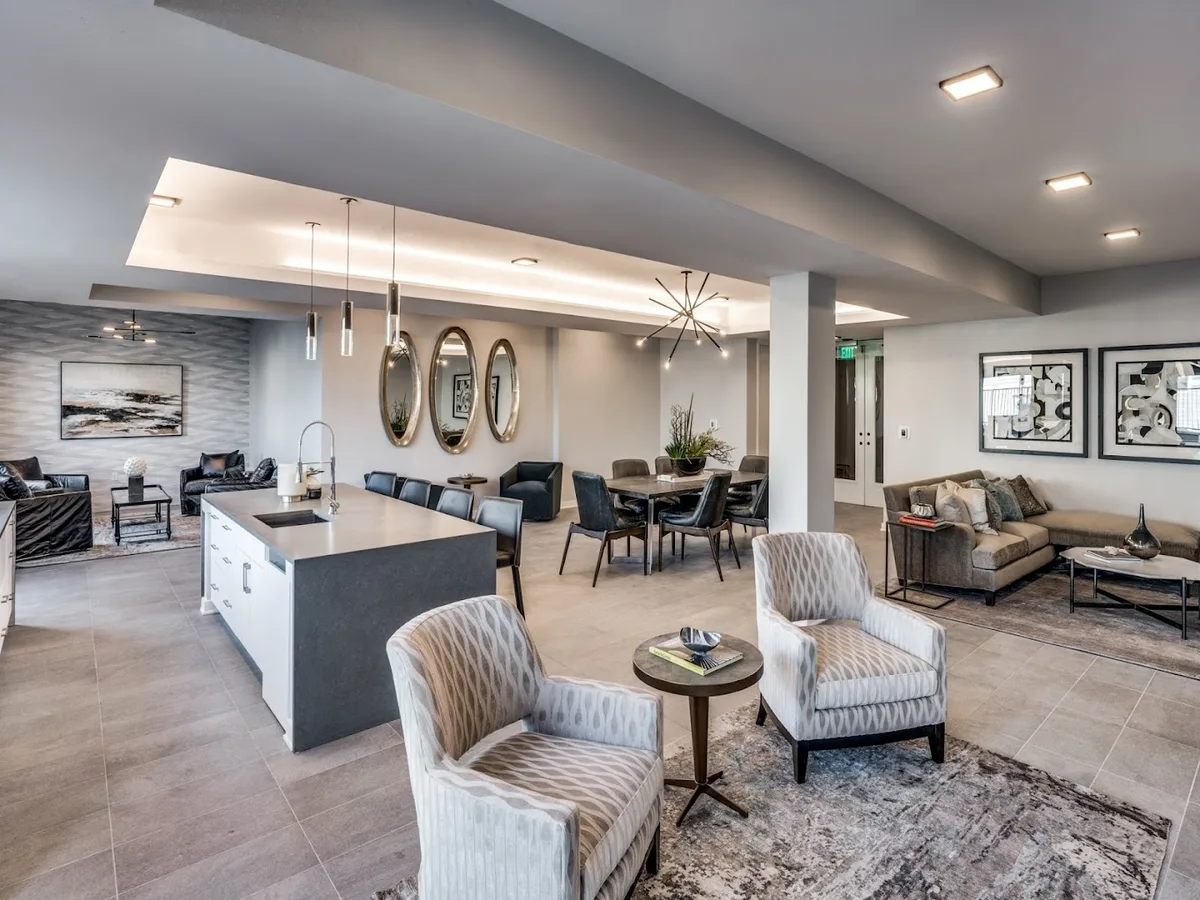 Resident clubroom with catering island, long dining table and lounge seating