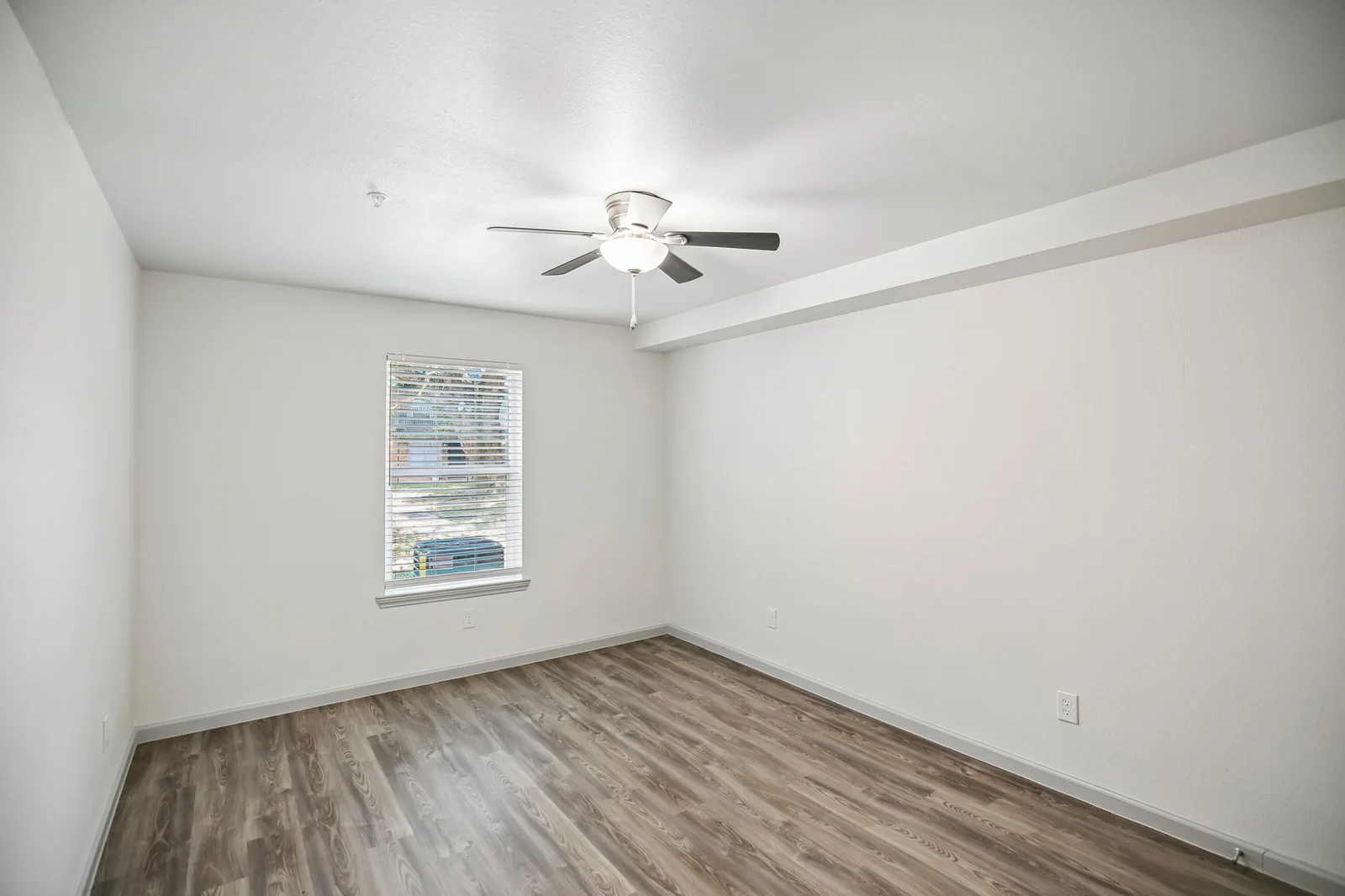 One-bedroom bedroom with a ceiling fan and wood-look flooring