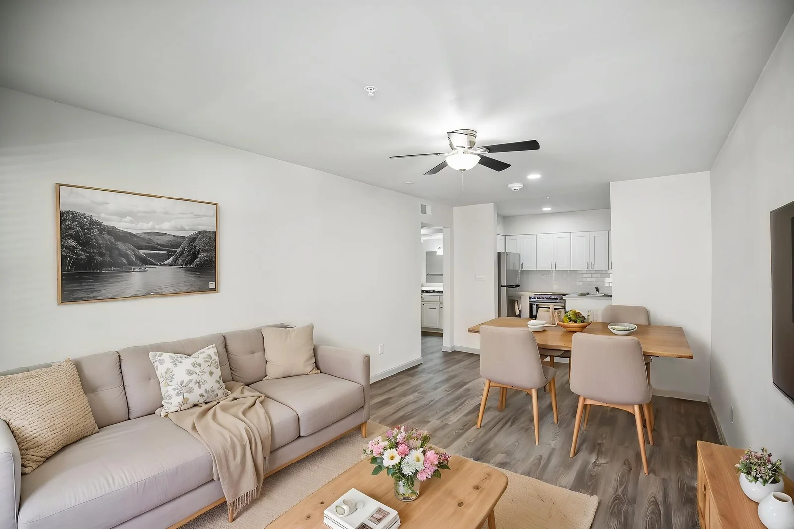 Virtually staged living and dining area in a renovated one bedroom with wood-look flooring