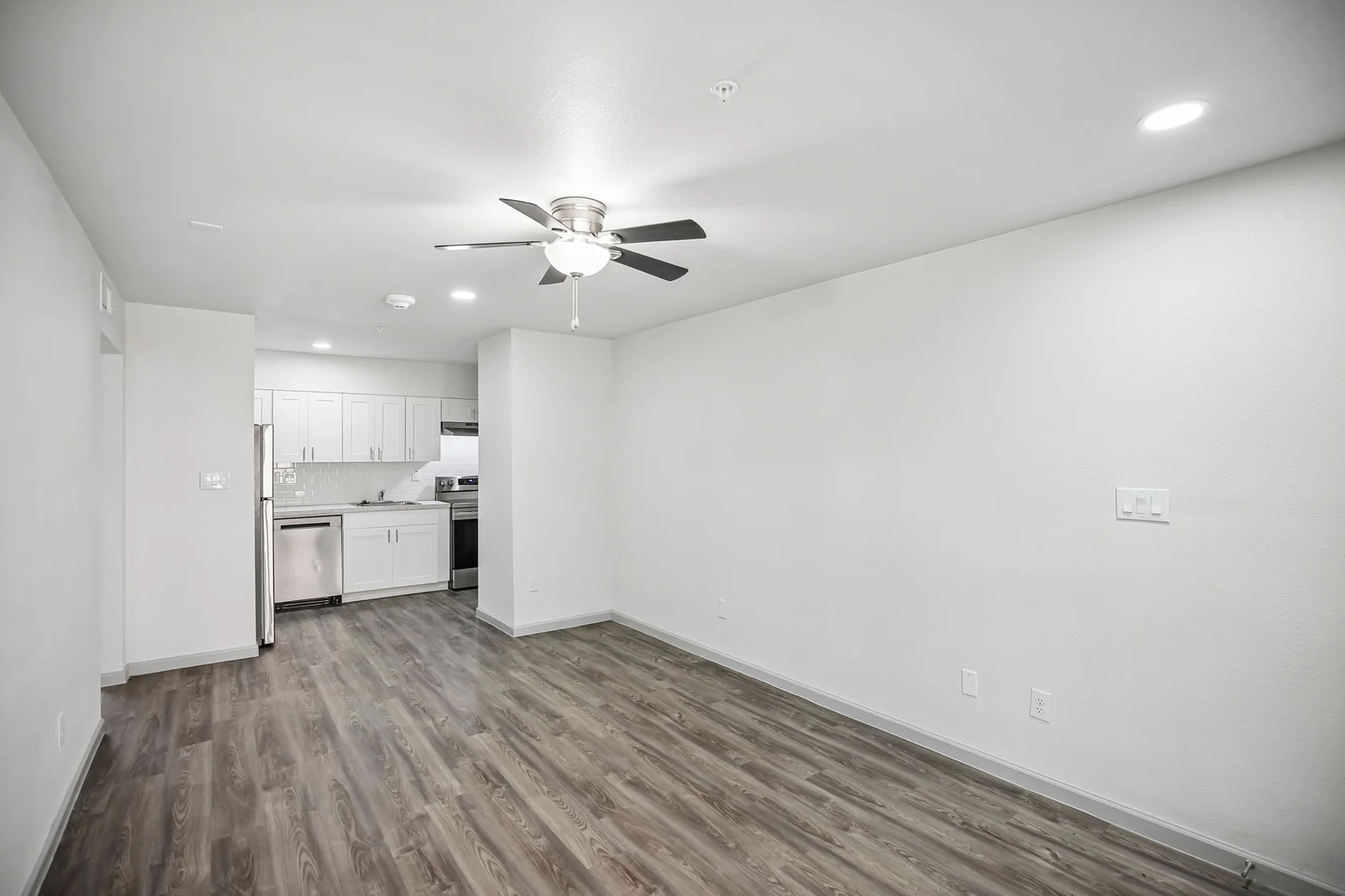 Renovated one-bedroom living area open to the white kitchen