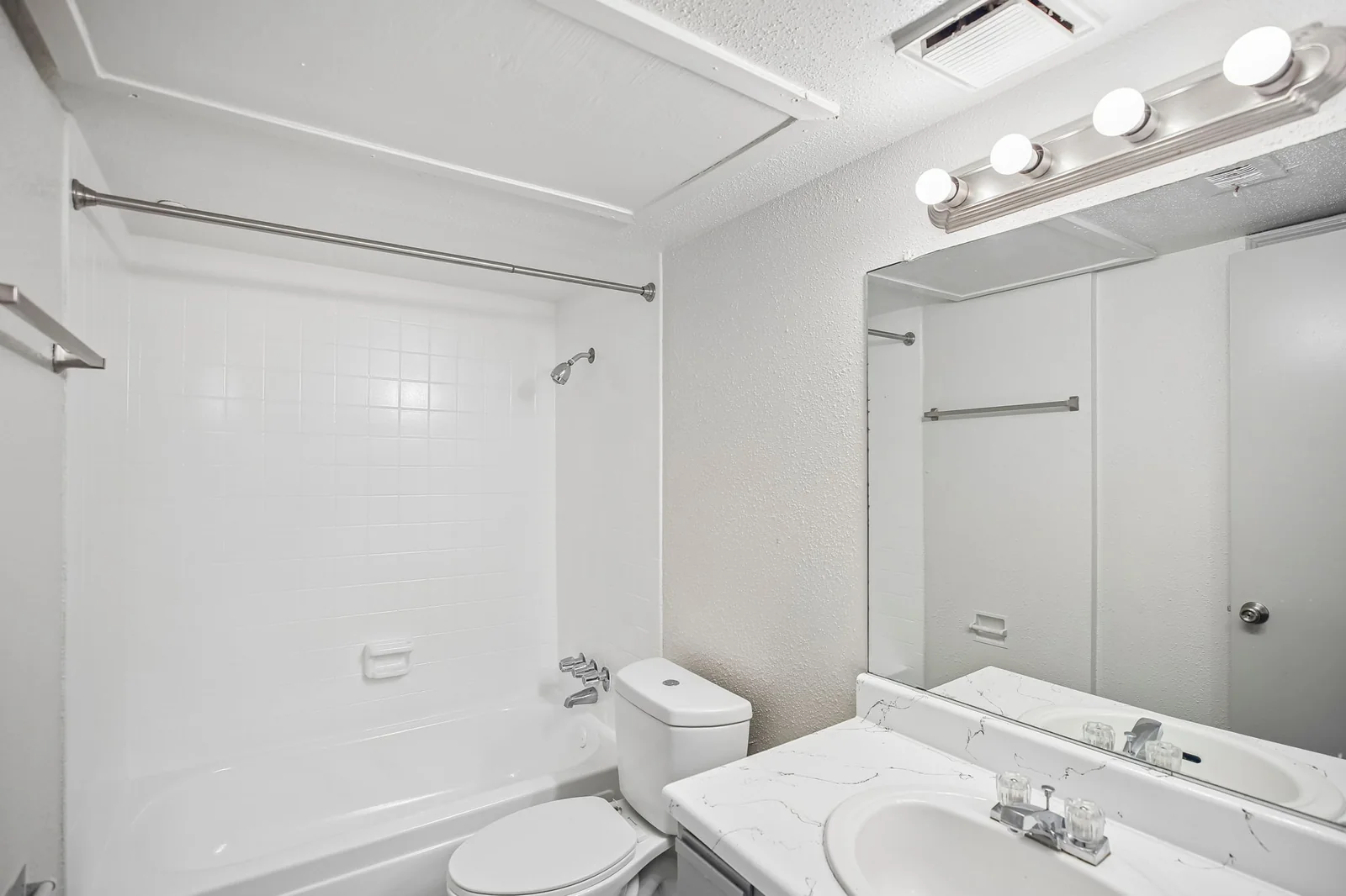 Two-bedroom bathroom with a tub-shower and marble-look vanity