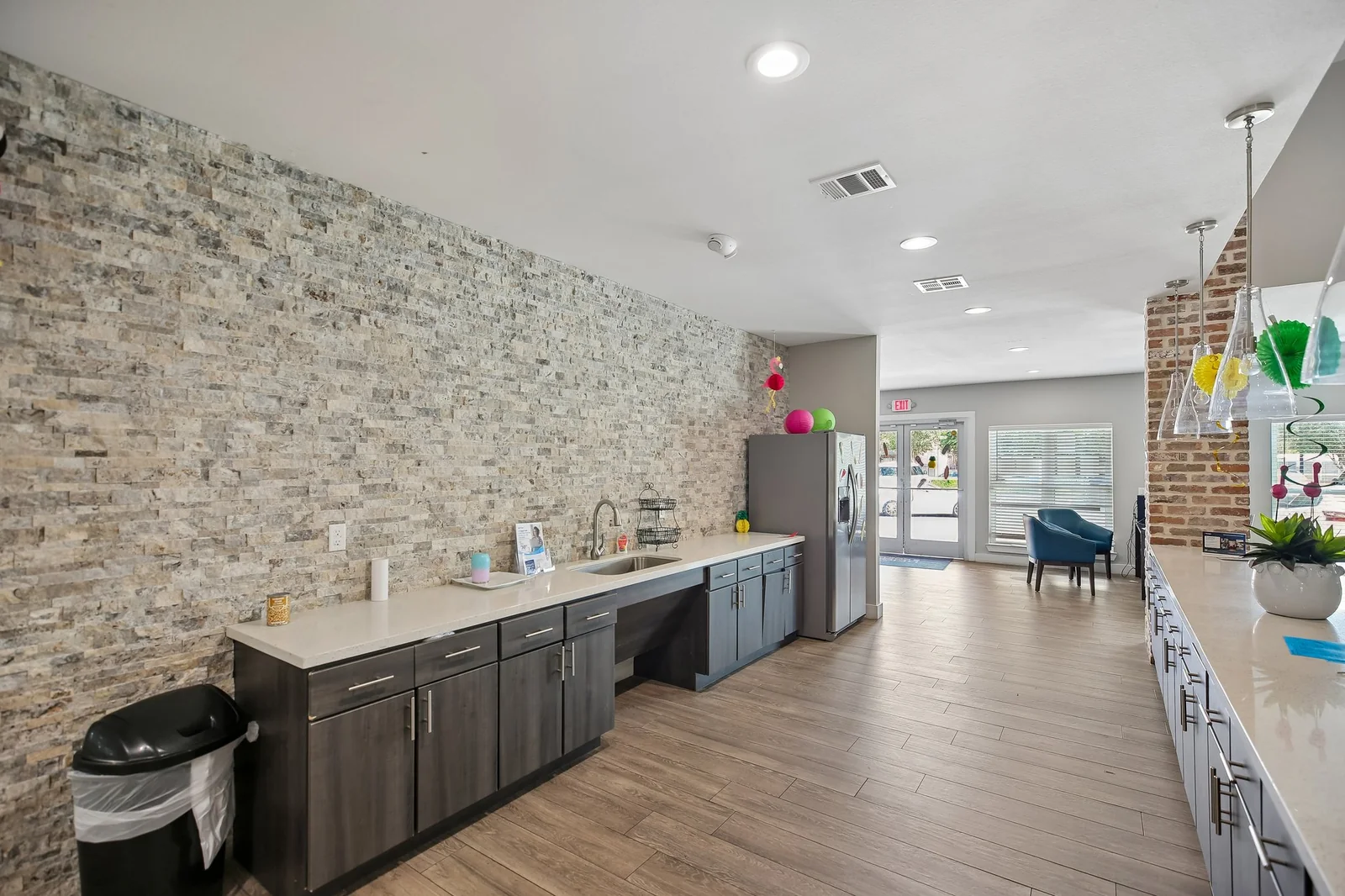 Clubhouse refreshment bar with a stacked-stone wall and dark cabinetry