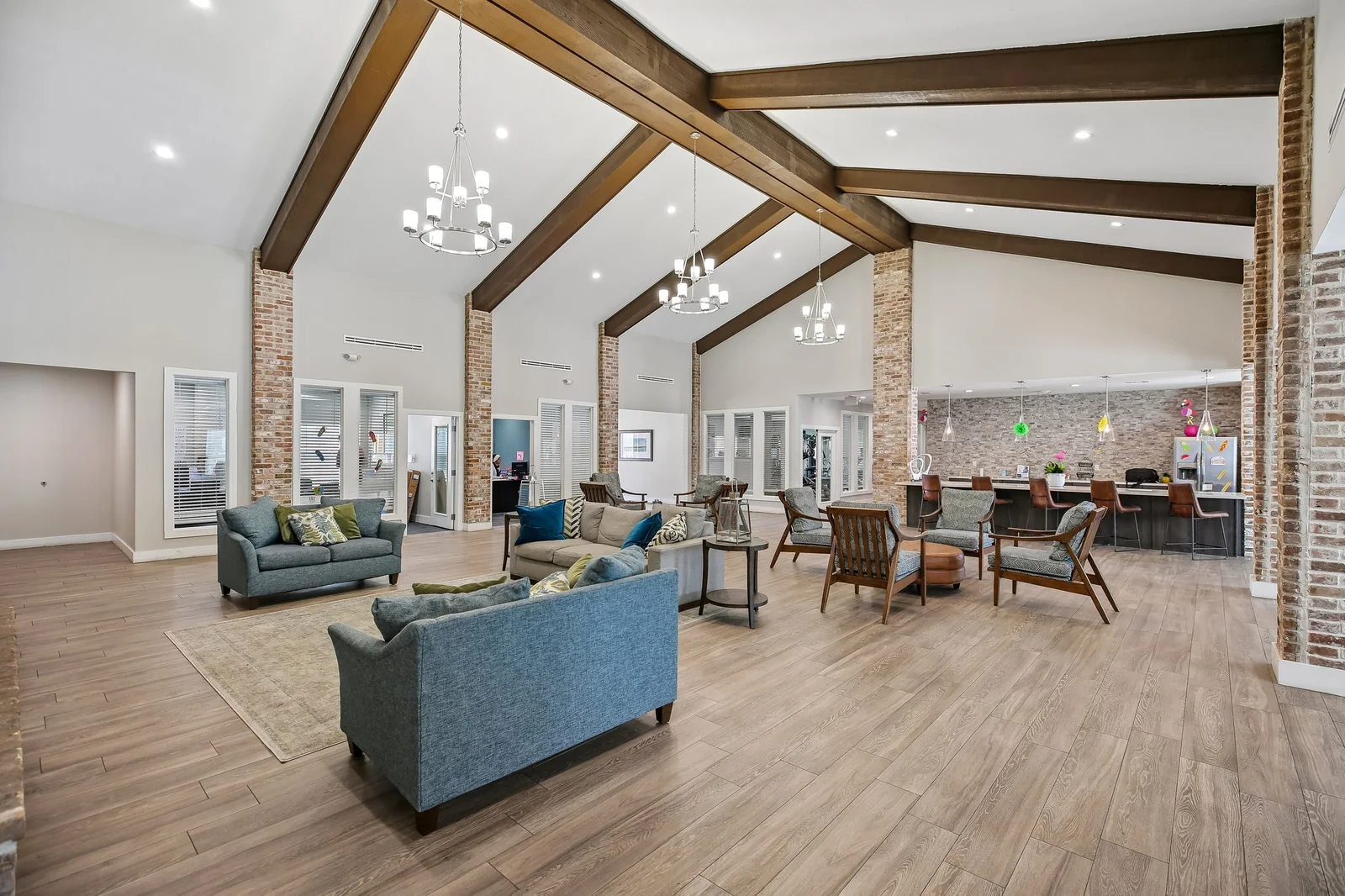 Renovated clubhouse lounge with exposed wood beams, brick columns, and seating groups