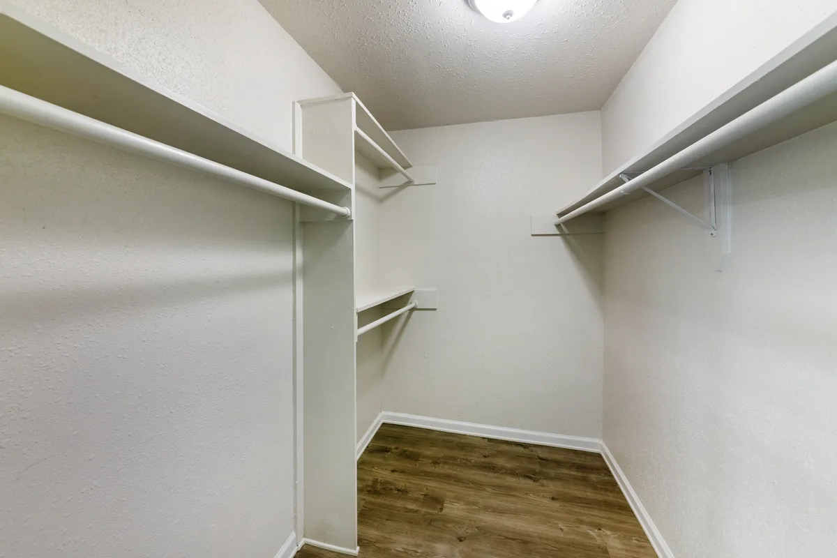 Walk-in closet with built-in shelving and hanging rods