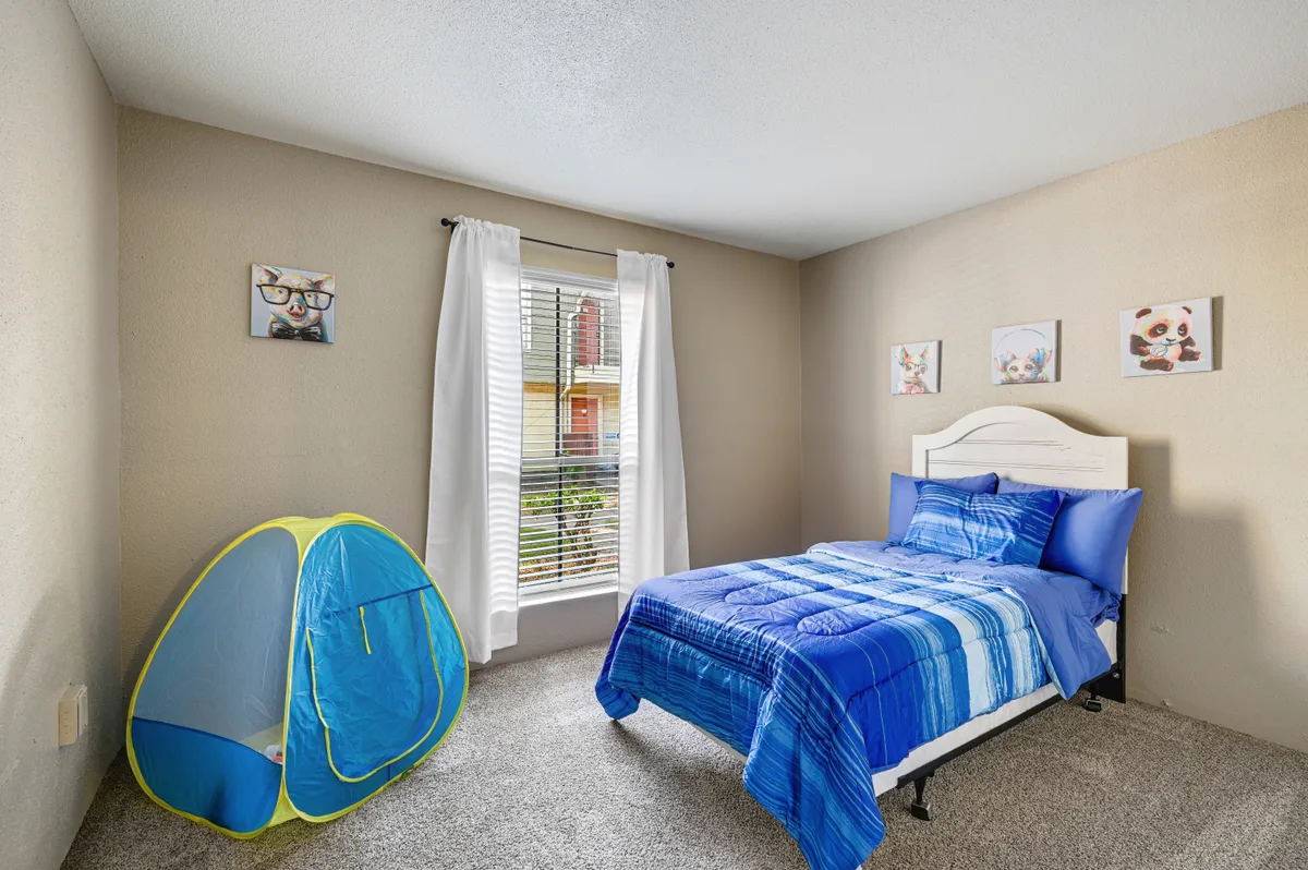 Children's bedroom with a twin bed, play tent, and carpeted flooring