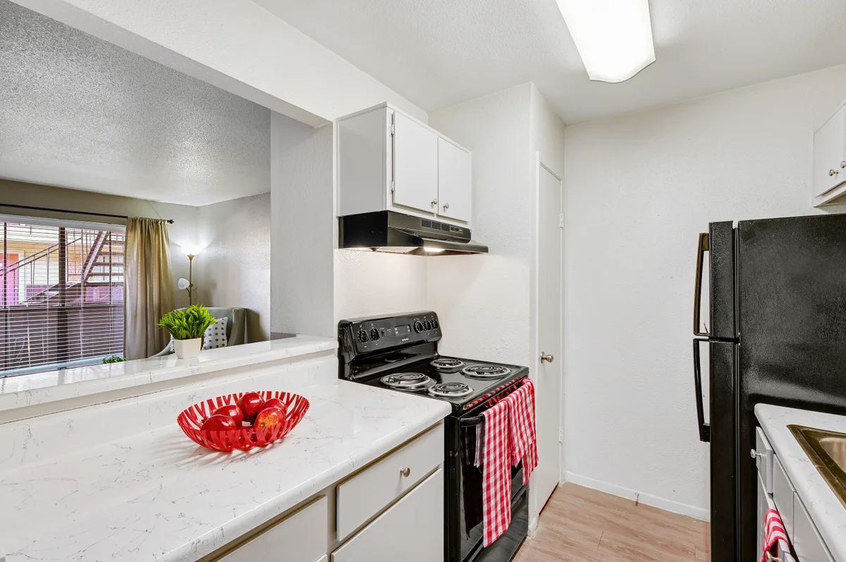 Galley kitchen open to the living area with a breakfast bar and black range