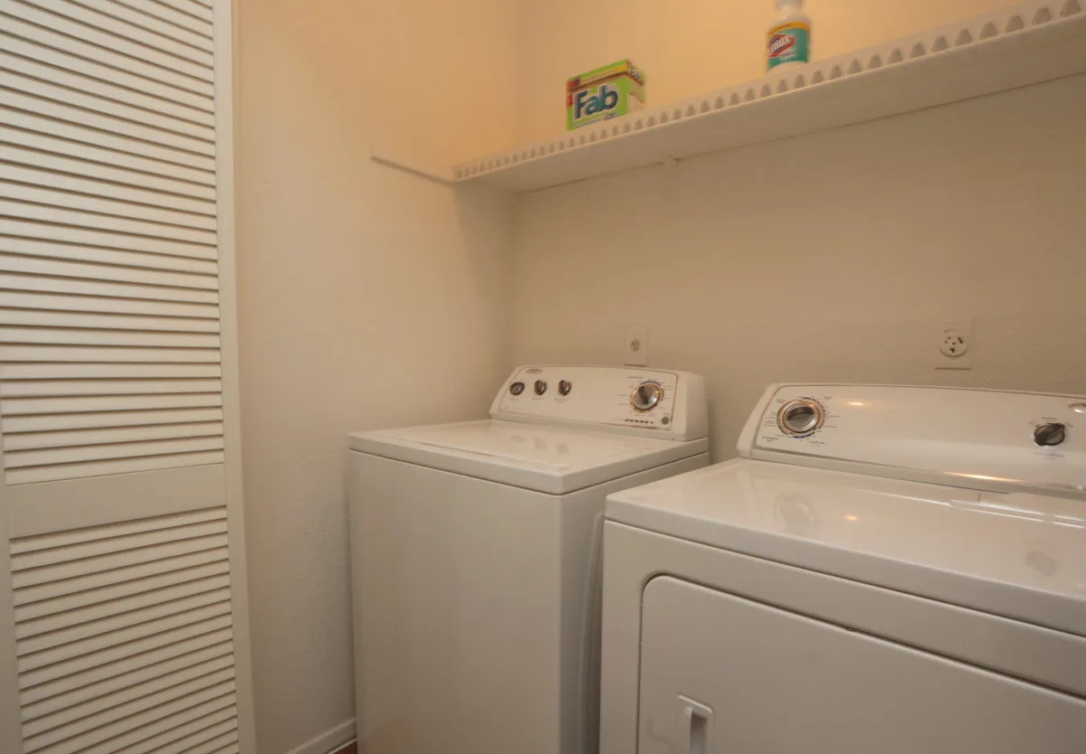 In-home full-size washer and dryer in a linen-shelved laundry closet