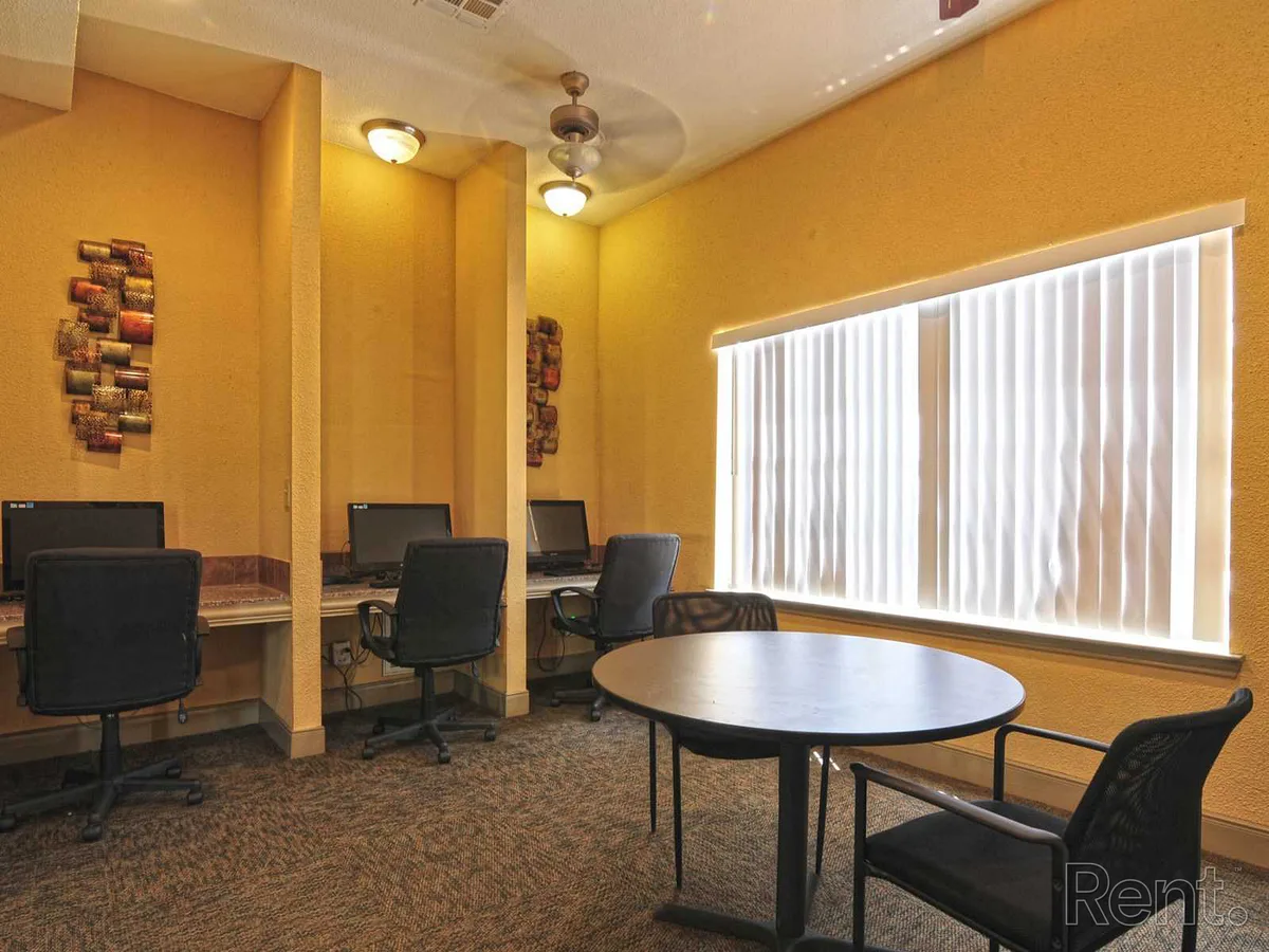 Resident business center with computer workstations and a round meeting table