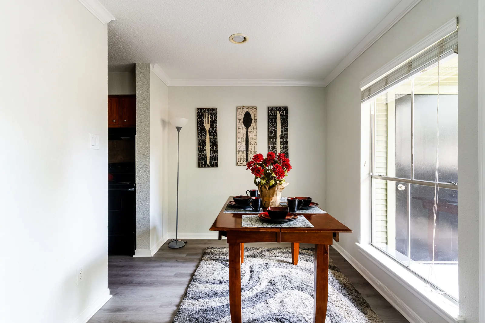 Dining nook with a wood table, floor lamp, and a large window