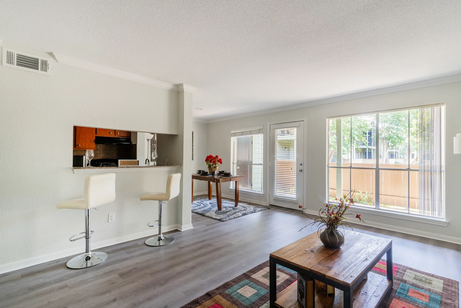 Living and dining space with a breakfast bar pass-through and large windows