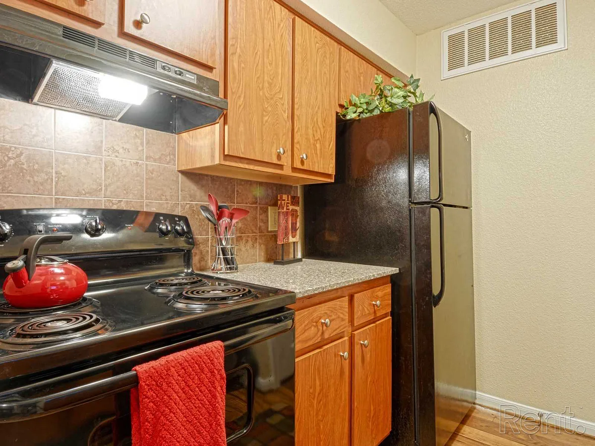 Kitchen with oak cabinets, granite-look counters, and black appliances