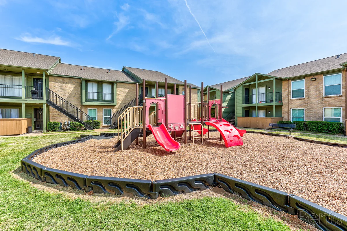 Wood-chip playground with slides and climbers between two apartment buildings