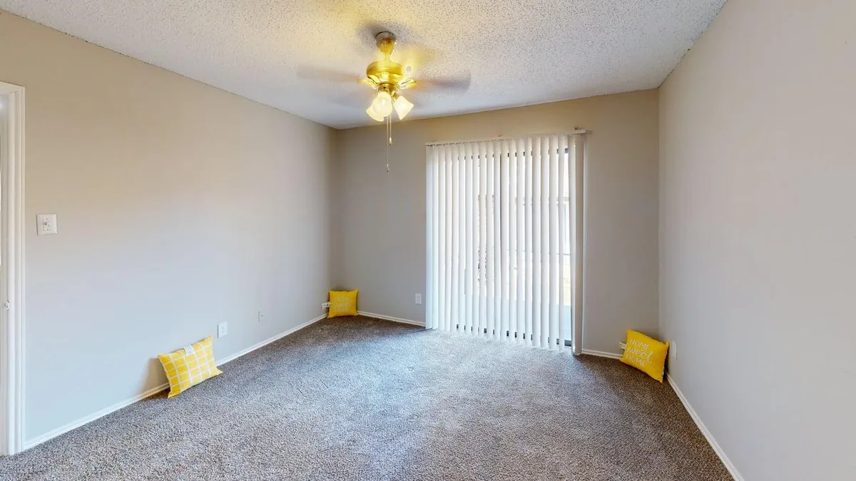 Carpeted primary bedroom with ceiling fan, walk-in closet, and ensuite bath access