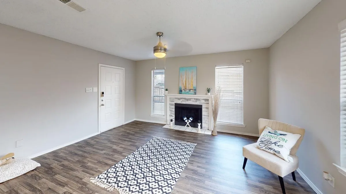 Living room with a stone-tile fireplace, wood-look floors, and lake-themed decor