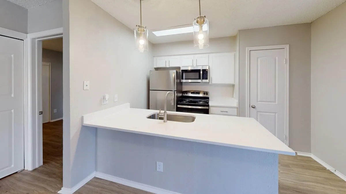 Kitchen with a peninsula breakfast bar, skylight, and stainless appliances
