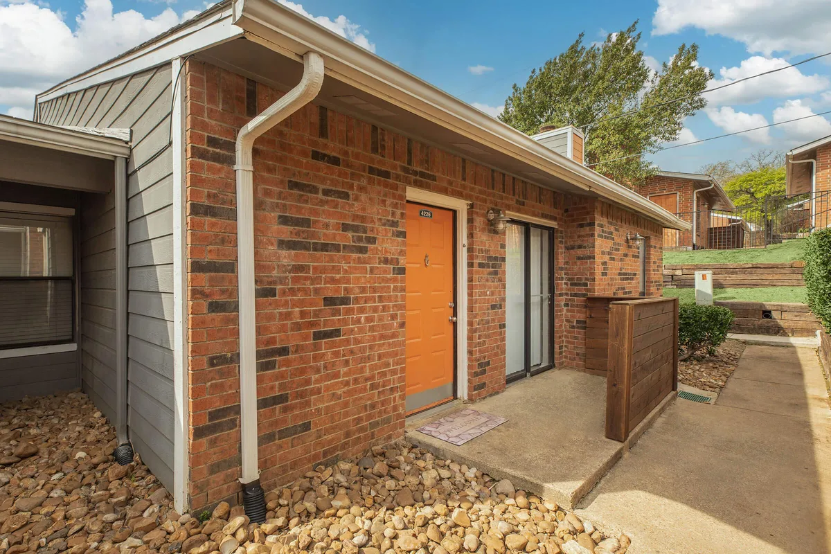 Private apartment entry with a covered patio and a brick facade