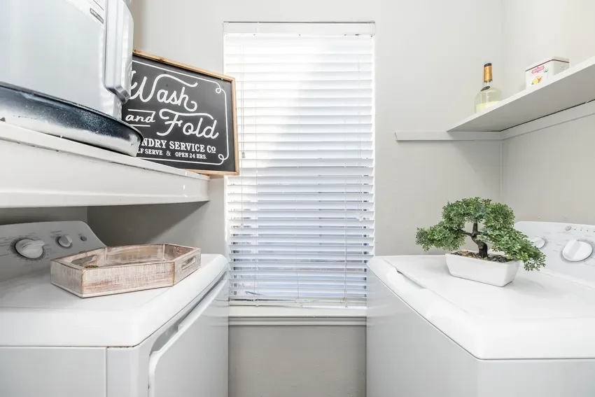 Shared self-serve laundry room with washers and dryers and a sunny window