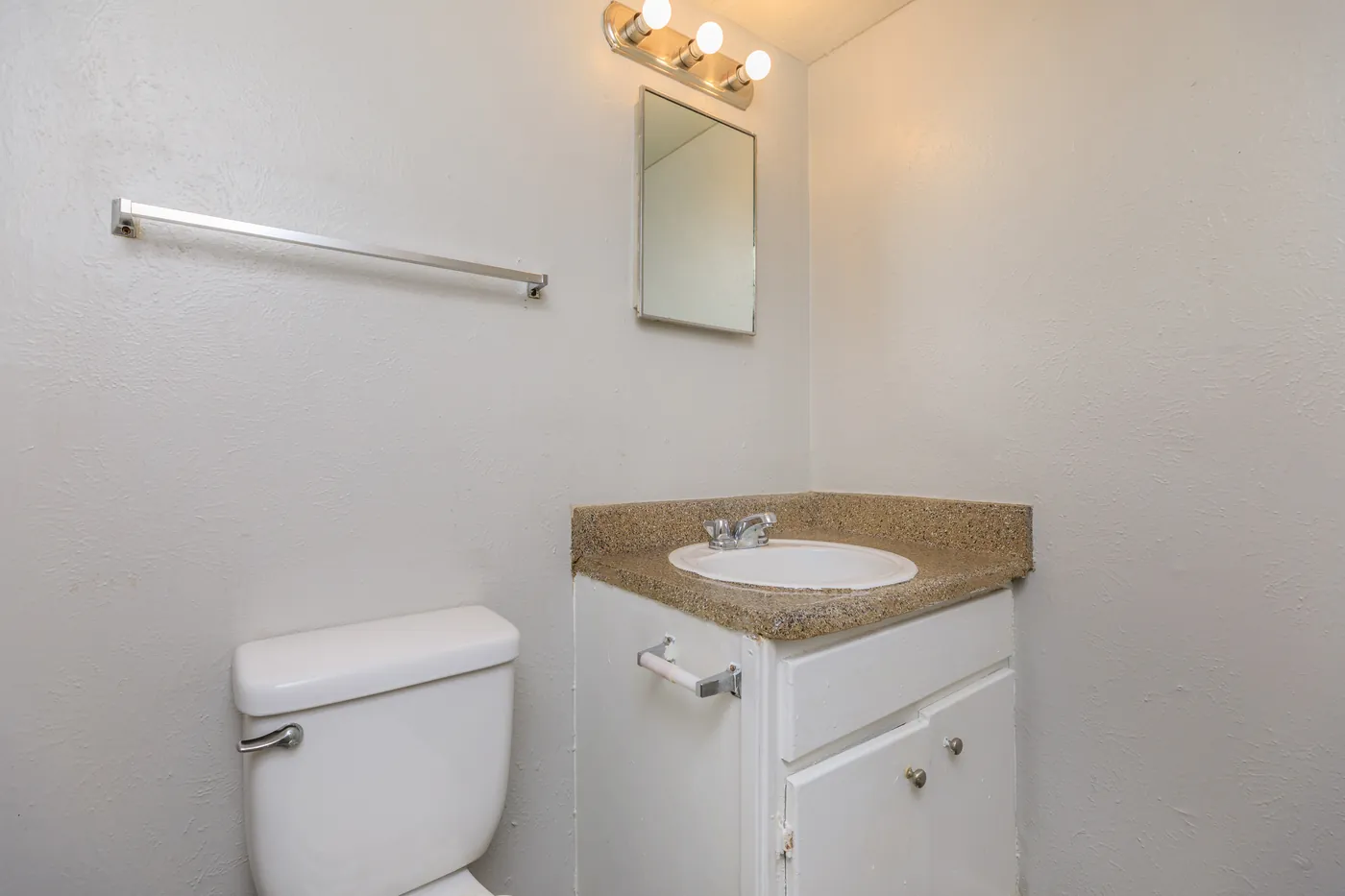 Bathroom with vanity, framed mirror, and towel bar