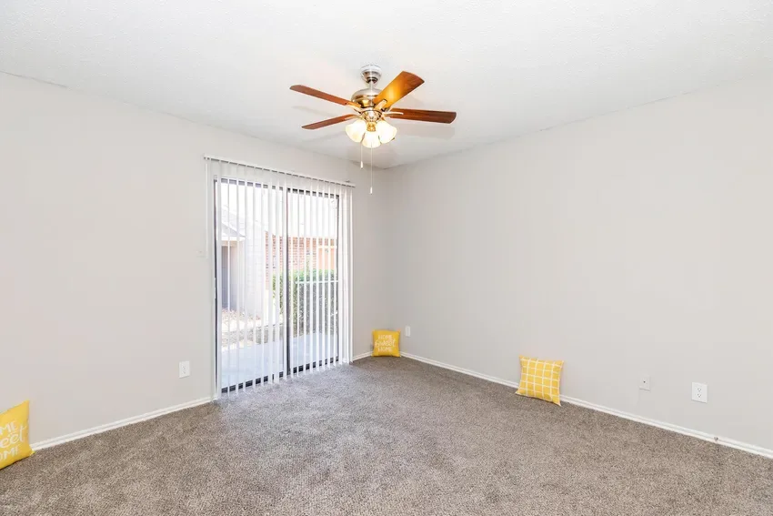 Carpeted bedroom with a ceiling fan and sliding-glass door to the patio