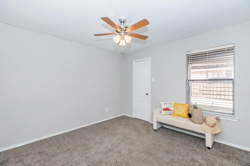 Carpeted bedroom with a closet, bright window, and ceiling fan