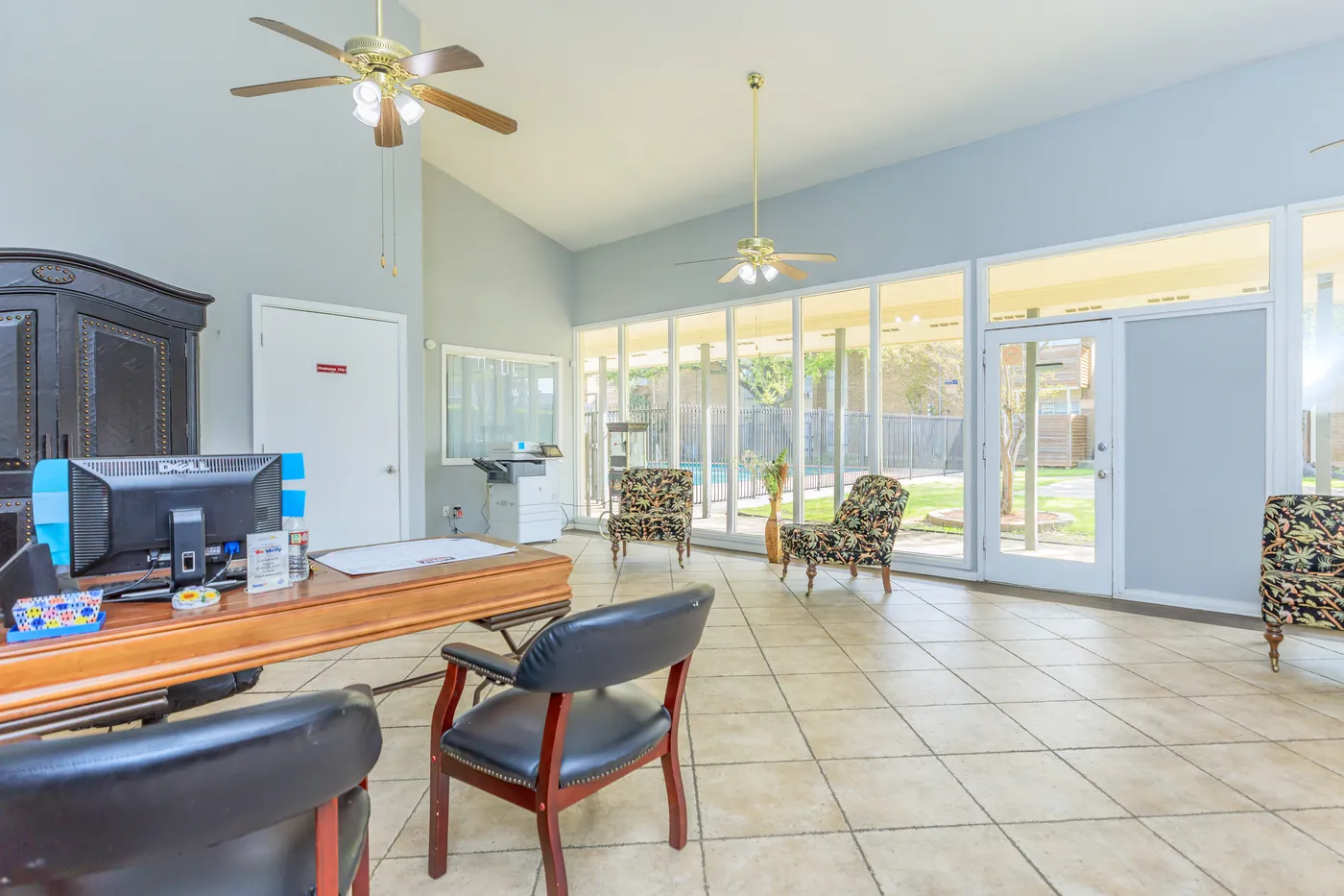 Leasing office interior with a service desk and the sunroom beyond