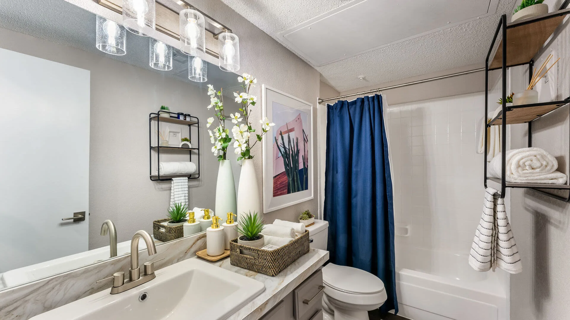 Bathroom with a marble-look vanity, tub and shower with a navy curtain