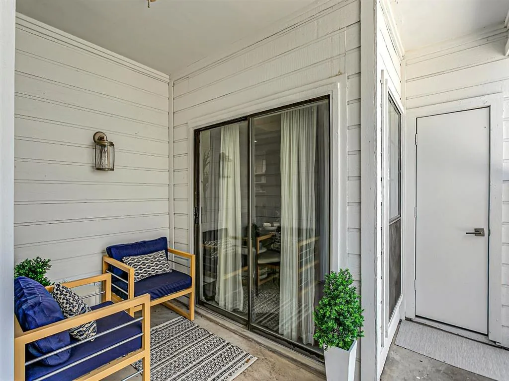 Private covered patio with outdoor seating and a sliding glass door